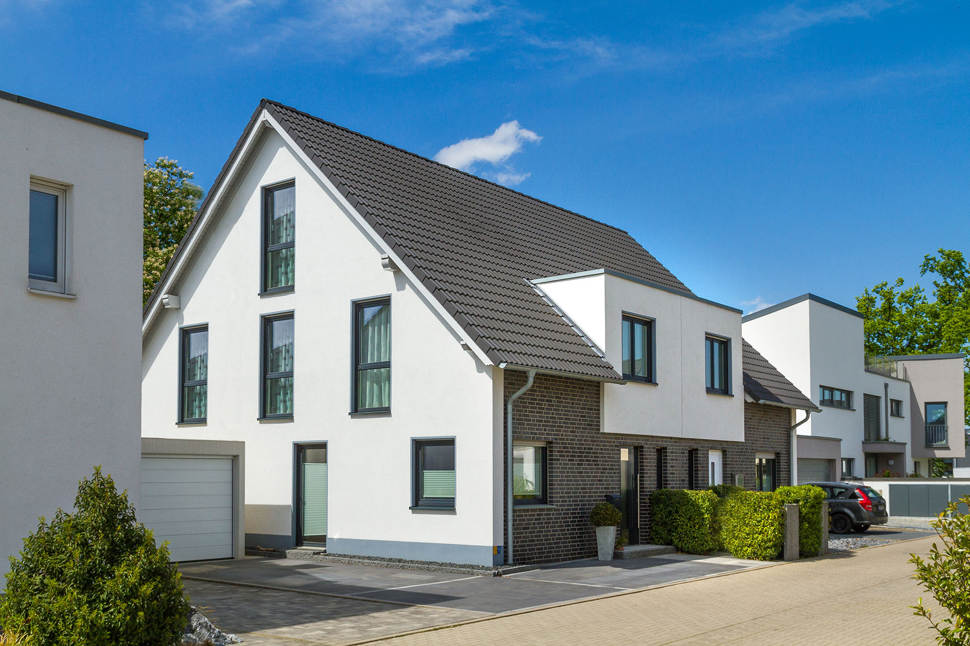 weißes Einfamilienhaus in einer Wohnsiedlung