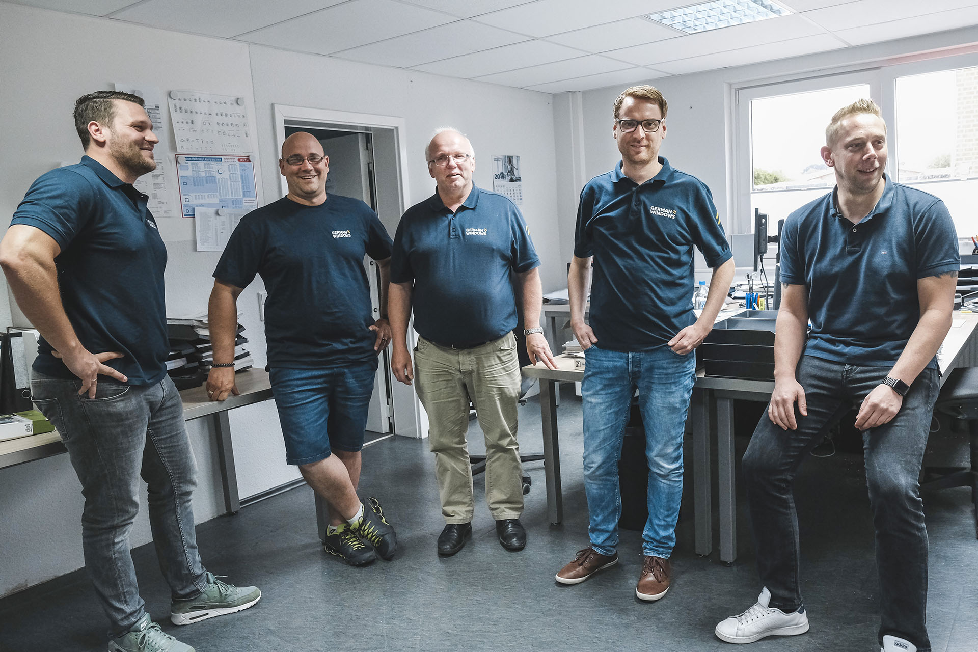 Fünf Personen, die sich im Büro unterhalten